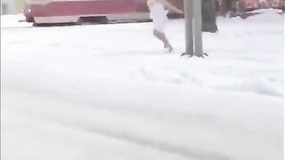 Woman Runs Through Snowy Street With Towel And Goes Underwater