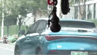 china man driving with officer on his vehicle