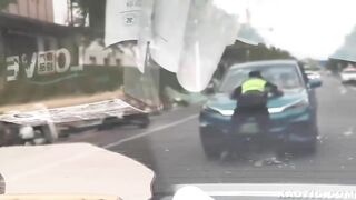 china man driving with officer on his vehicle