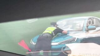 china man driving with officer on his vehicle