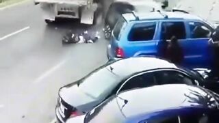 Man Trapped Between Reversing Car And Passing Truck 